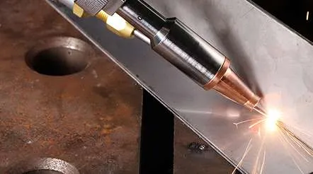 Close-up of a handheld laser welding torch cutting steel with sparks
